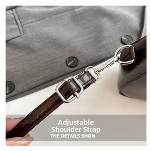 Detail of adjustable dark brown patent leather shoulder strap with silver metal buckle