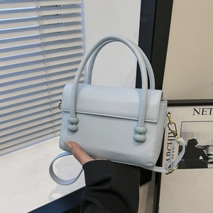 Modern light blue pebble leather handbag with round hardware and detachable shoulder strap