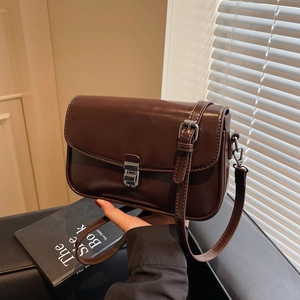 Brown vintage square leather crossbody bag with silver buckle in natural soft light