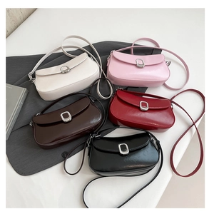 Flat lay of small crossbody bags in five colors with silver square buckles on a blazer
