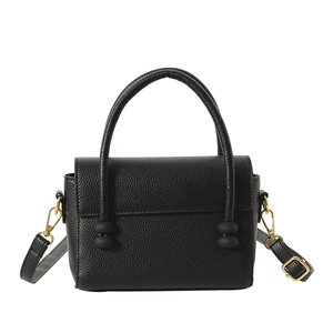Elegant black lychee grain handbag with matte beads and gold hardware on white background