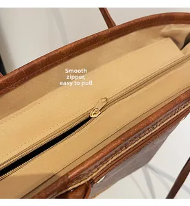 Detail of high-quality smooth golden metal zipper on brown vintage leather tote bag