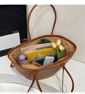 Interior view showing the large capacity of a woven straw tote bag with brown leather details