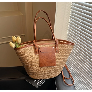 Detailed texture of straw woven tote bag with brown leather pocket and metal rivets