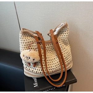 Detail of hand-woven crochet tote bag with brown leather straps and cloud charm