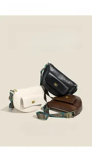 Détail de trois sacs à bandoulière en noir, beige et marron avec des sangles à motifs