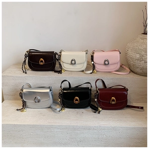 Detailed arrangement of six colorful leather saddle bags on minimalist stone stairs