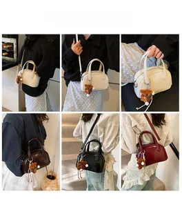 Chic bowling bag in four colors styled with a bear charm on a female model