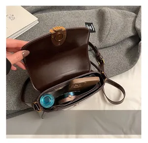 Deep brown saddle bag interior view showing space for phone and cosmetics