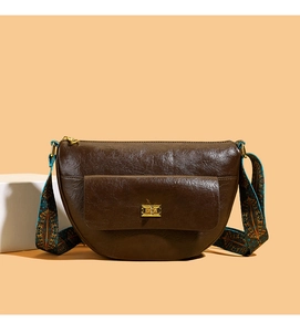 Détail du sac besace marron en cuir avec boucle dorée et bandoulière tissée bohème