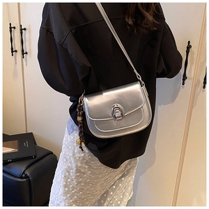 Close-up of a silver saddle bag featuring a metallic finish and a unique multi-ring buckle