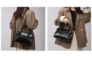 Close-up of black crossbody bag with silver twist lock and woven handle detail