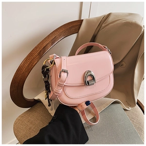 Detailed view of pink saddle bag with silver U-shaped buckle and leather strap