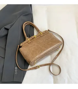 Dettaglio della borsa tote in pelle marrone retrò con texture antica e fibbia metallica