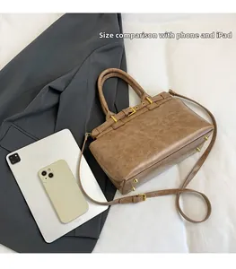 Confronto dimensioni della borsa vintage marrone con smartphone e tablet