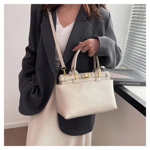 Dettaglio della borsa tote in pelle crema con fibbia dorata e tracolla sottile