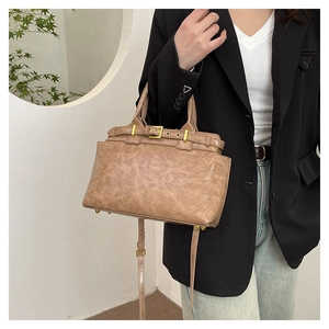 Borsa tote vintage marrone con dettagli dorati mostrata come accessorio a mano elegante