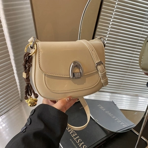 Chic milk tea leather saddle bag with silver horseshoe buckle and woven charm