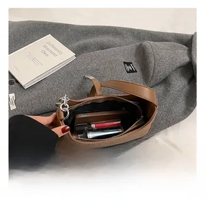 Interior view of brown leather shoulder bag showing capacity for phone and lipstick