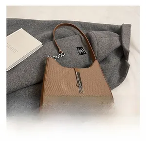 Detailed close-up of brown woven texture bag with silver metal buckle and chain strap