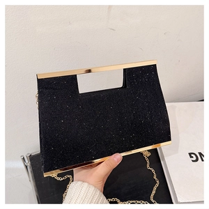 Dettaglio pochette da sera nera glitterata con manico a trapezio dorato e catenina