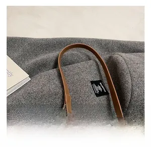 Detailed macro shot of brown woven underarm bag with thick silver chain link hardware