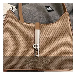 Detailed macro view of the silver metal lock and textured canvas fabric of the underarm bag