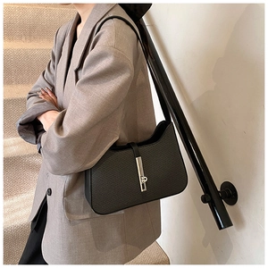 Détail du sac sous l'aisselle en cuir tressé noir avec boucle en métal argenté