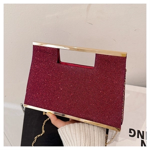 Dettaglio della borsa da sera con paillettes rosse, manico in metallo e catena