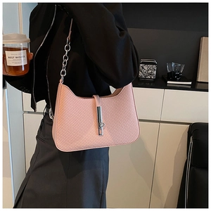 Détail du sac sous le bras rose tissé avec boucle en métal argenté et bandoulière chaîne