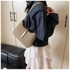 Détail du sac sous le bras kaki avec texture tissée, chaîne en métal et boucle argentée