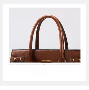 Detail of brown leather tote bag showing gold rivets and smooth grain texture