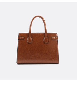 Detail of vintage brown faux leather texture and metallic buckles on tote bag