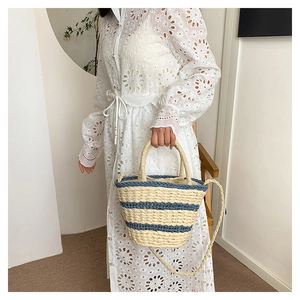 Détail du sac seau en paille tissée à la main avec rayures bleues et cordon