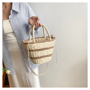 Détail d'un sac seau en paille tressée à rayures avec doublure à cordon de serrage