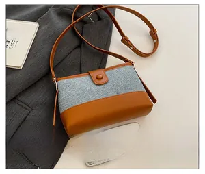Detail shot of vintage contrast-color crossbody bag with adjustable leather strap and buckle