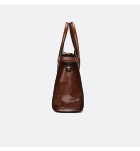 Detail of dark brown leather tote bag showing side D-ring and smooth vintage texture