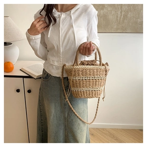Détail du sac seau en paille tressée avec doublure à cordon kaki et bandoulière