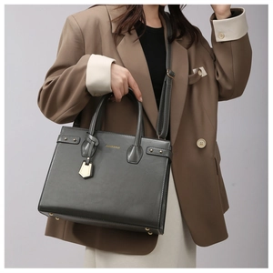 Detail view of dark grey tote bag featuring gold hardware and adjustable shoulder strap
