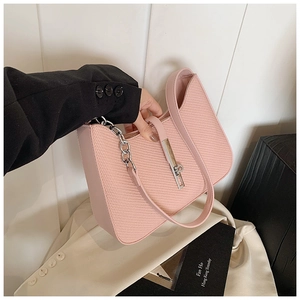 Détail de texture du sac à main rose tressé avec chaîne argentée et fermoir métal