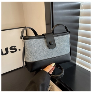 Detail of the denim and black leather contrast shoulder bag with a matte snap button