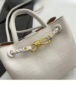 Detail showing creamy crocodile pattern leather with elegant golden knot hardware clasp
