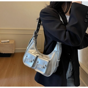 Detail of silver metallic crescent bag with utility pockets and adjustable strap