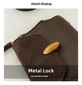 Detail of vintage gold hardware clasp on dark brown leather and suede crossbody bag