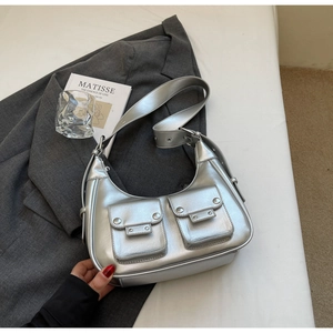 Detailed shot of silver metallic underarm bag with Y2K studs and dual front flap pockets