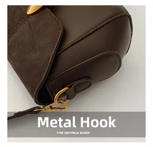 Detail of dark brown leather handbag with gold metal hook and fine stitching craftsmanship