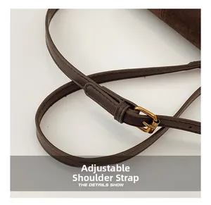 Detail of adjustable dark brown leather strap with polished gold buckle and fine stitching