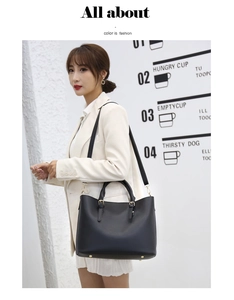 Fashionable black pebbled leather tote bag with dual handles and long shoulder strap