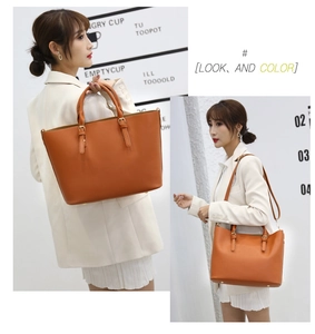 Detailed view of caramel brown tote bag showing smooth faux leather texture and gold hardware