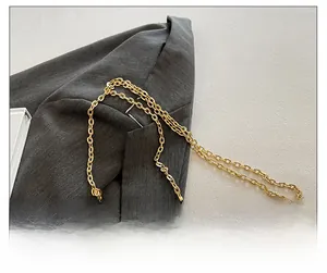Detail of elegant gold chain strap and textured shell-shaped acrylic crossbody bag